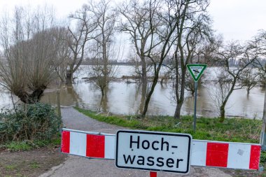 fence on river coast in Germany indicating high tide and flood water with flooded coastline after broken dike