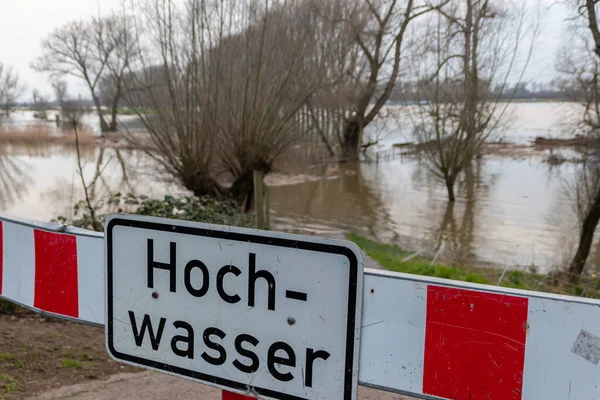 fence on river coast in Germany indicating high tide and flood water with flooded coastline after broken dike