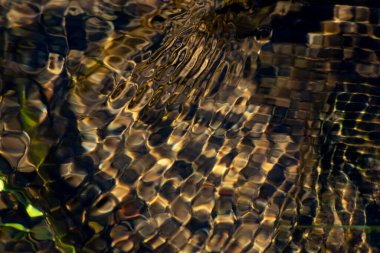 Kristal berrak bir su deresinin suyundaki ipeksi dalgalar, yüksek açılı doğal arka plan, temiz yüzen bir dereyle sağlıklı bir dağ pınarındaki zen meditasyonunu ve küçük dalgaları gösterir.