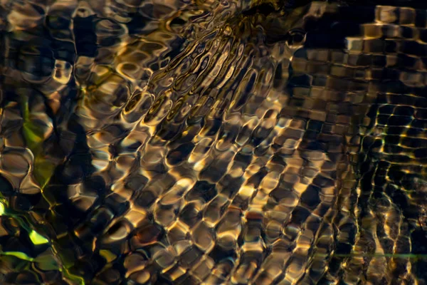 Silky ripples in water of a crystal clear water creek as idyllic natural background with high angle view shows zen meditation and little waves in a healthy mountain spring with a clear floating stream