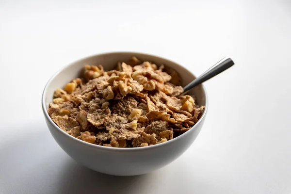 Breakfast cereals with healthy cornflakes and delicious walnuts and honey in a bowl are the perfect start in the day and ideal for dietary lifestyle and healthy food for dieting and school breakfast