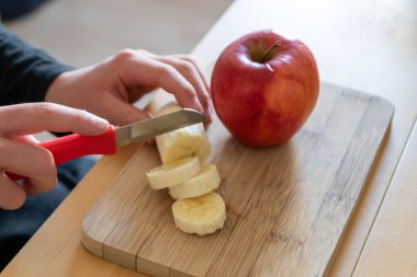 Avrupalı çocuk elleri, kahvaltıda kırmızı elma ve muz gibi keskin bir bıçakla meyve kesiyor ya da mutfak masasında vitaminlerle beslenen bir diyet yemeği gibi vitaminli atıştırıyor.