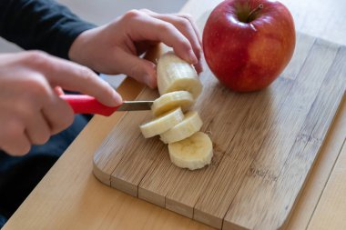 Avrupalı çocuk elleri, kahvaltıda kırmızı elma ve muz gibi keskin bir bıçakla meyve kesiyor ya da mutfak masasında vitaminlerle beslenen bir diyet yemeği gibi vitaminli atıştırıyor.