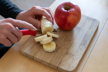 Avrupalı çocuk elleri, kahvaltıda kırmızı elma ve muz gibi keskin bir bıçakla meyve kesiyor ya da mutfak masasında vitaminlerle beslenen bir diyet yemeği gibi vitaminli atıştırıyor.
