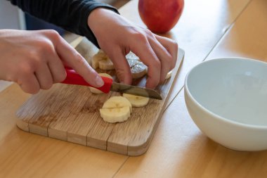 Avrupalı çocuk elleri, kahvaltıda kırmızı elma ve muz gibi keskin bir bıçakla meyve kesiyor ya da mutfak masasında vitaminlerle beslenen bir diyet yemeği gibi vitaminli atıştırıyor.