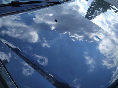 Arabasında bulutlar olan gökyüzünün yansıması