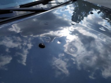 Arabasında bulutlar olan gökyüzünün yansıması