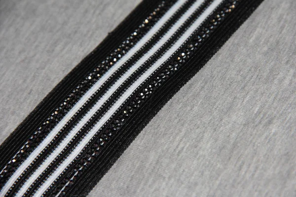 Black and white line with rhinestones on grey fabric