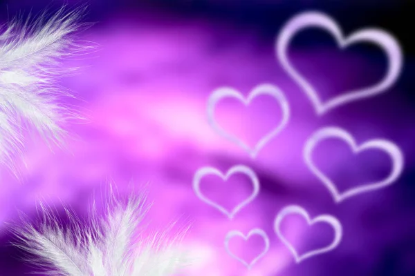 Purple blurred background with hearts and feathers