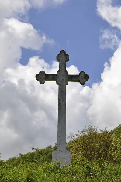 Cruz de pedra contra no céu azul — Fotografia de Stock