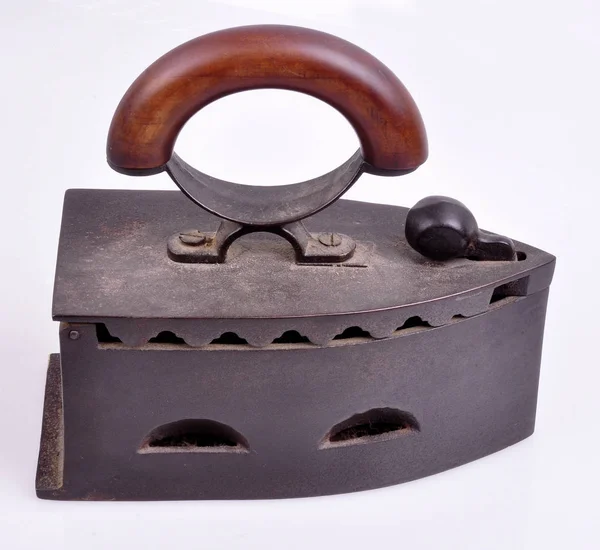 Um antigo inóculo de ferro fundido com uma pega de madeira sobre um fundo branco — Fotografia de Stock