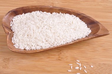 Beyaz bir arka plan ile ahşap bir kasede pirinç