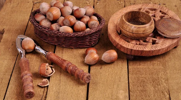 Hazelnuts in basket with walnut on wooden background — Stock Photo, Image