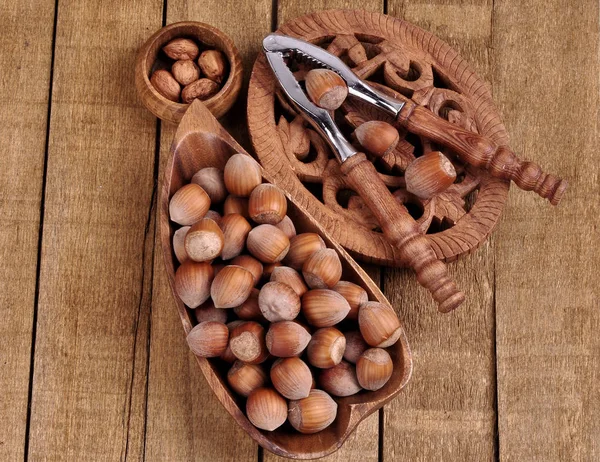 Hazelnuts in basket with walnut on wooden background — Stock Photo, Image