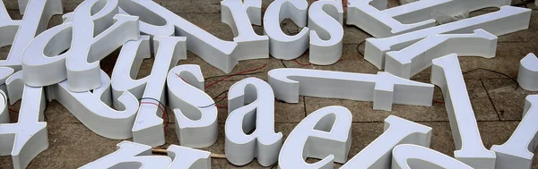 Lettres tridimensionnelles de lettres blanches destinées à faire des publicités sont dispersées sur le sol — Photo