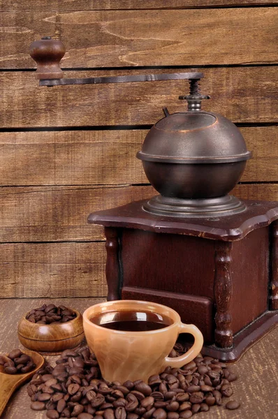 Vieux moulin à café en bois et grains de café torréfiés sur une table en bois. Café chaud frais en tasse — Photo