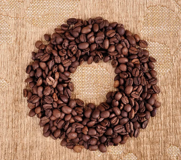 Chicchi di caffè formando cerchio forma su sfondo astratto — Foto Stock