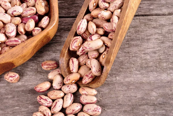 Colored beans in a wooden bowl on an old wooden background — Stock Photo, Image