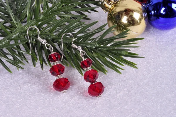 Küpe ile Noel ağacı dalı üzerinde kırmızı taşlarla bir — Stok fotoğraf