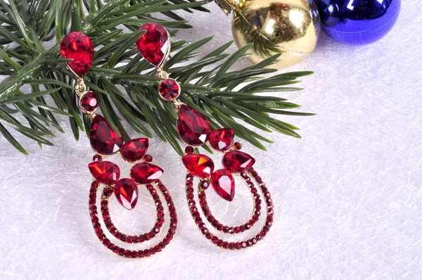 Boucles d'oreilles avec des pierres rouges sur une branche d'un arbre de Noël avec un — Photo