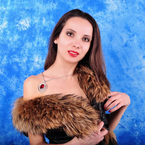 Young girl with a pendant dressed in a fur coat — Stock Photo, Image
