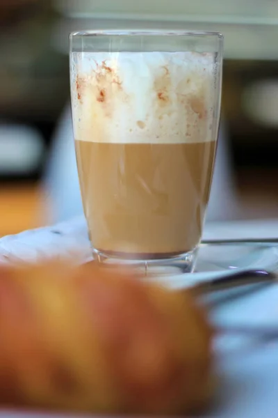 Egy kávézó és egy croissant közeli részletei egy kávézó asztalon. — Stock Fotó