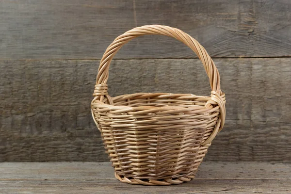 Empty basket for harvesting on a wooden background.
