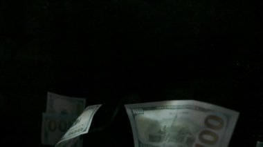 4K Loopable 'daki siyah arka planda düşen Amerikan doları banknotları. 4K 'da yüksek kalitede düşen dolar banknotları. Görüntü Döngüsel