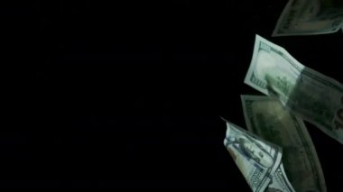 4K Loopable 'daki siyah arka planda düşen Amerikan doları banknotları. 4K 'da yüksek kalitede düşen dolar banknotları. Görüntü Döngüsel