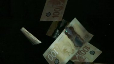 4K Loopable 'daki siyah arka planda düşen Amerikan doları banknotları. 4K 'da yüksek kalitede düşen dolar banknotları. Görüntü Döngüsel