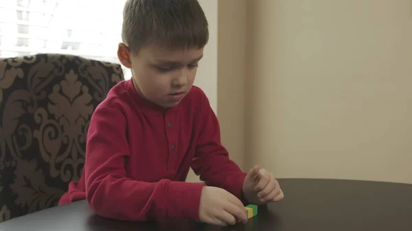Niño pequeño, preescolar jugando con bloques de madera. Caucásico chico en un rojo suéter edificio con bloques . —  Fotos de Stock