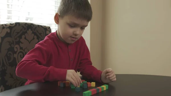 Niño pequeño, preescolar jugando con bloques de madera. Caucásico chico en un rojo suéter edificio con bloques . —  Fotos de Stock