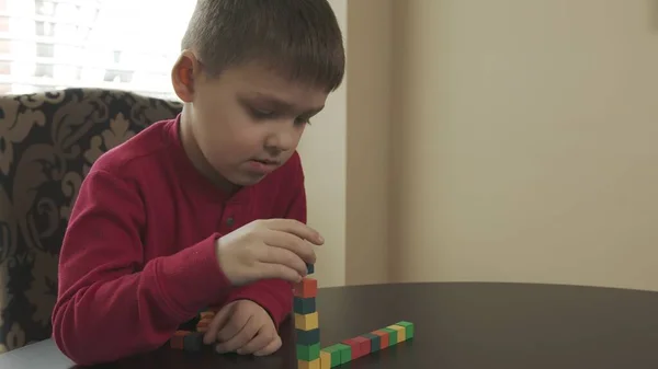 Niño pequeño, preescolar jugando con bloques de madera. Caucásico chico en un rojo suéter edificio con bloques . —  Fotos de Stock