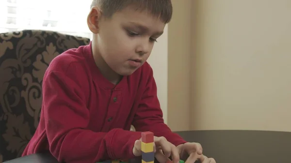 Niño pequeño, preescolar jugando con bloques de madera. Caucásico chico en un rojo suéter edificio con bloques . —  Fotos de Stock