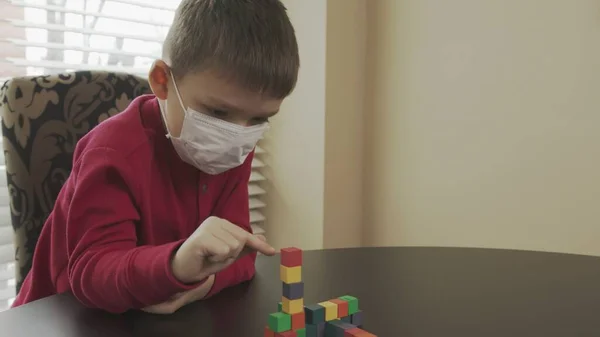 Niño pequeño, preescolar jugando con bloques de madera. Caucásico chico en un rojo suéter edificio con bloques . — Foto de Stock