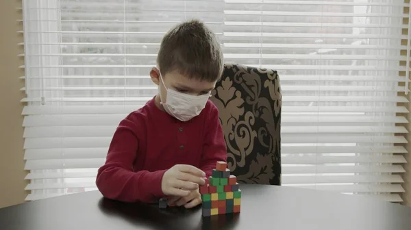 Niño pequeño, preescolar jugando con bloques de madera. Caucásico chico en un rojo suéter edificio con bloques . — Foto de Stock