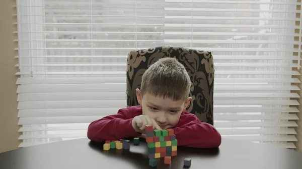 Niño pequeño, preescolar jugando con bloques de madera. Caucásico chico en un rojo suéter edificio con bloques . —  Fotos de Stock