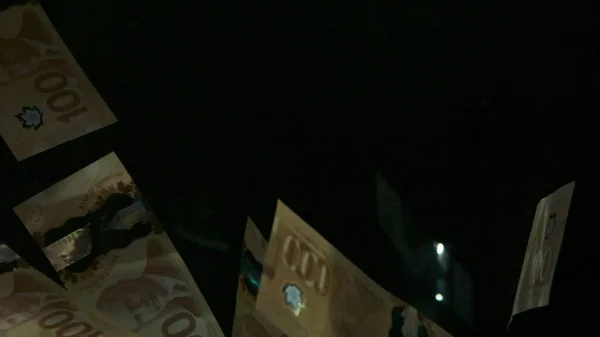 Billets volants en dollars canadiens américains sur fond noir. Billets Dollar de haute qualité en baisse — Photo
