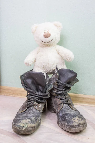 Juguete infantil y viejas botas del ejército . — Foto de Stock