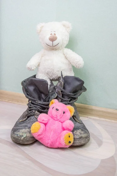 Juguete infantil y viejas botas del ejército . — Foto de Stock