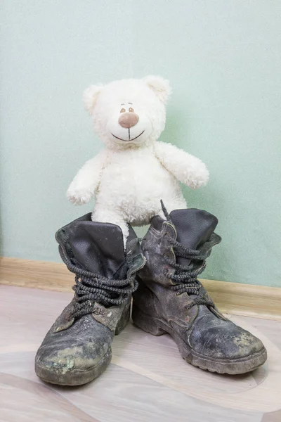 Juguete infantil y viejas botas del ejército . — Foto de Stock