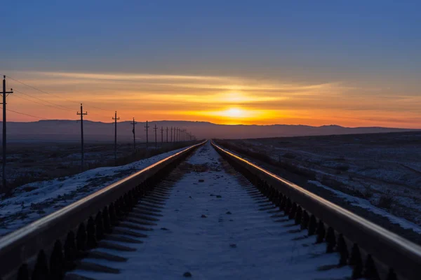 Ferrocarril retrocediendo a la distancia al amanecer Fotos de stock libres de derechos