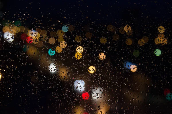 Gotas de lluvia en las luces de color de cristal por la noche . Fotos de stock