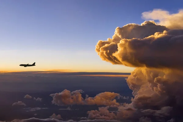 A Storm Front at Sunset with an Airplane in front of the storm