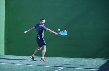 Kürek topu turnuvası. Çimlerin üzerinde klasik vuruş duruşu olan oyuncu