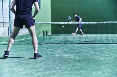 Kürek tenis turnuvası. Rakipler çim tarlasında iş başında. Düşük görünüm