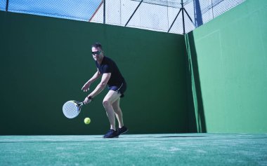 Kürek topu turnuvası. Çimlerin üzerinde klasik vuruş duruşu olan oyuncu