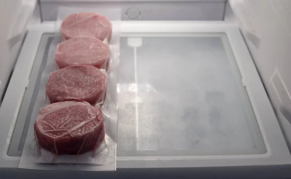 set of frozen meat packed in plastic inside a refrigerator