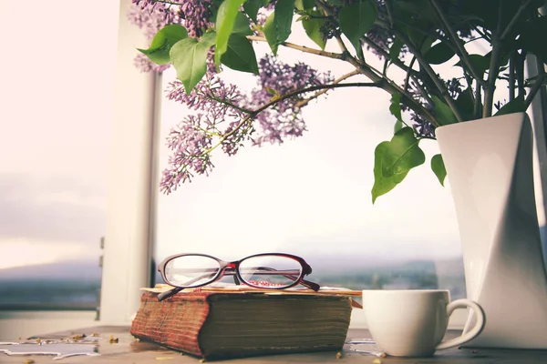 Lilás, livro e café na mesa — Fotografia de Stock