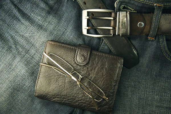 wallet and glasses on jeans